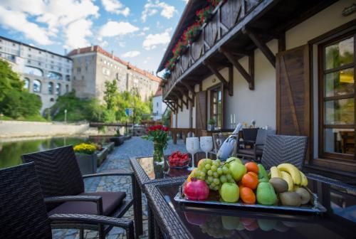 uma bandeja de frutas sobre uma mesa na varanda em Garni hotel Castle Bridge em Cesky Krumlov
