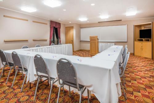 a conference room with white tables and chairs and a whiteboard at Baymont by Wyndham Plainfield/ Indianapolis Arpt Area in Plainfield