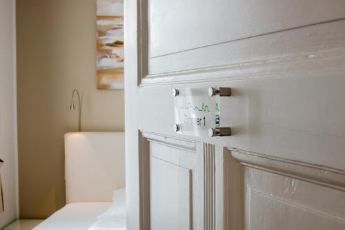 ein Badezimmer mit einer weißen Tür mit einem Schild darauf in der Unterkunft Landhotel Alte Töpferei in Duisburg