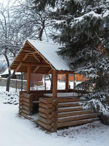 a wooden cabin with a snow covered roof at АртГір гостинний двір in Mykulychyn