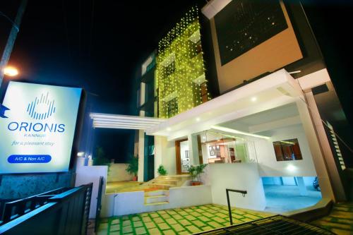 a building with a sign in front of it at night at Orionis Kannur in Kannur