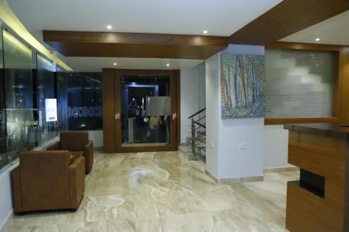 a lobby with a couch and a chair in a building at Orionis Kannur in Kannur