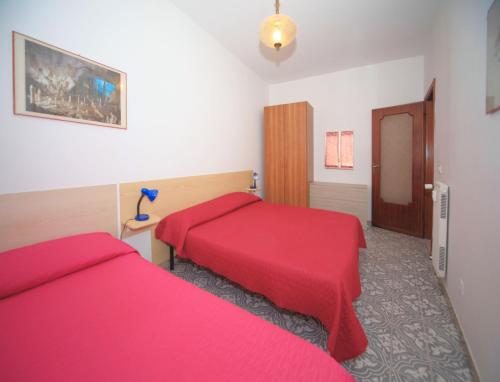 ボルゲット・サント・スピーリトにあるLa Conchigliaのベッド2台 ホテルルーム 赤いシーツ付