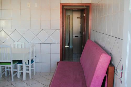 a pink couch in a room with a table at Pousada Açoriana in Florianópolis