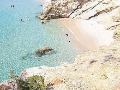 a beach with people swimming in the water at Villa Mediterraneo in Chia
