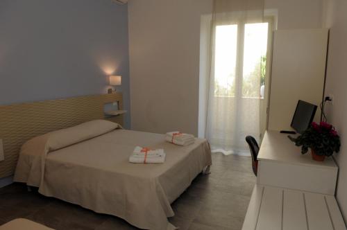 1 dormitorio con 1 cama, TV y ventana en Della torre rooms en Lecce