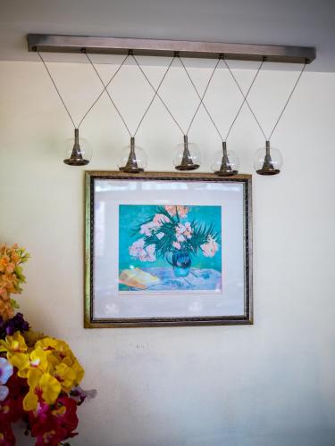 a picture hanging on a wall with lights at Chomsin Hua Hin ชมสินธุ์ หัวหิน in Hua Hin