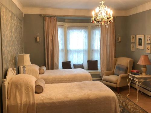 a bedroom with two beds and a chandelier at Penley House Bed & Breakfast in Auburn
