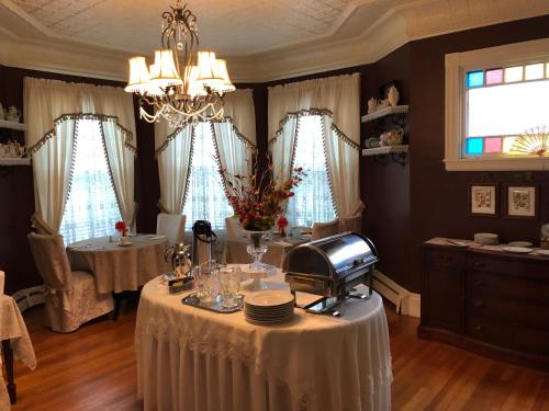 a dining room with a table with plates and a machine at Penley House Bed & Breakfast in Auburn