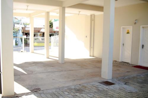 an empty hallway of a building with white columns at Pousada Açoriana in Florianópolis