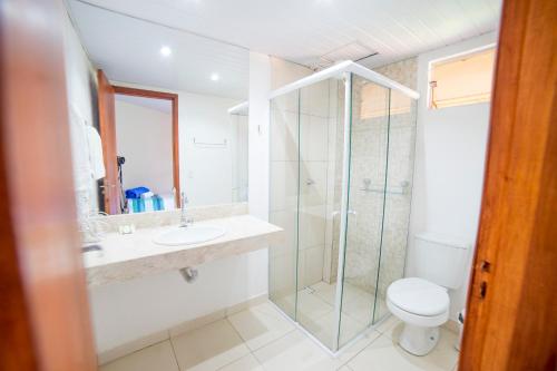 a bathroom with a shower and a toilet and a sink at Pousada Muito Bonito in Bonito