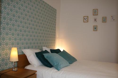 a bedroom with a white bed with blue pillows at Alcaiceria in Granada