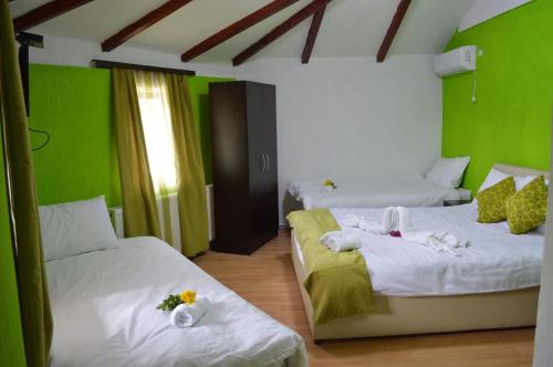 2 camas en una habitación con paredes verdes en Etno Restoran Ranc en Radibuš