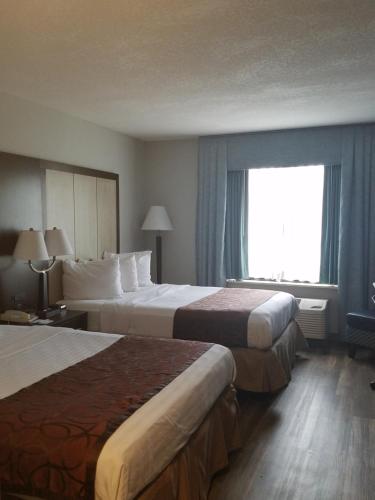 a hotel room with two beds and a window at Wyndham Garden Hotel - Jacksonville in Jacksonville