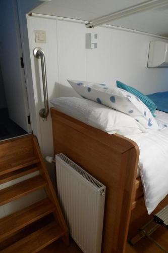 a small bedroom with a bed and a staircase at B&B Barge Johanna in Bruges