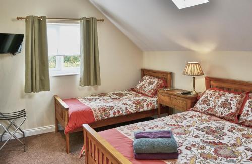 a small bedroom with two beds and a window at Farthing Cottage in Norwich