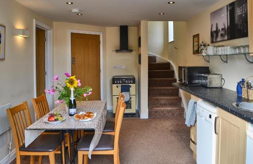 a kitchen and dining room with a table and chairs at Farthing Cottage in Norwich