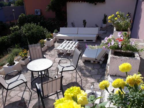 a patio with a table and chairs and flowers at Maritimo Apartments in Kotor