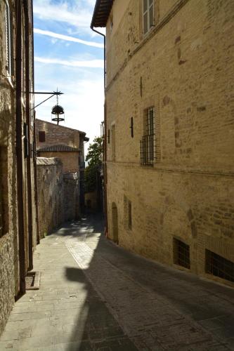 an alley with a shadow of a building on a street at Camere Calocci in Assisi