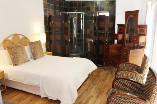 a bedroom with a bed and a glass shower at Golden Key Guesthouse in Vredenburg