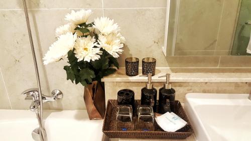 a bathroom with a sink and a tray with toiletries at Astra Suites Night Bazaar in Chiang Mai