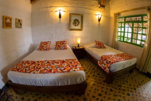 a bedroom with two beds and a window at Hotel La Coqueta in Montenegro