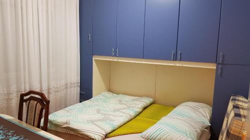 a small room with a bed and blue cabinets at Apartment MA 2 , 3 rd floor in Banja Luka