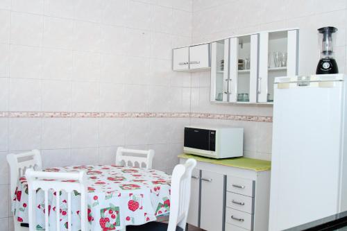 a kitchen with a table and chairs and a microwave at Pousada Açoriana in Florianópolis