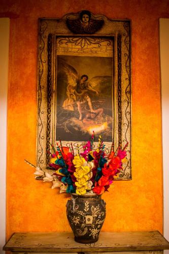 a vase with flowers on a table in front of a painting at Casona Tlaquepaque Temazcal & Spa in Guadalajara