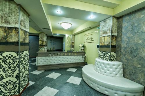 a salon with a waiting room with a chair at Prestige Boutique Hotel Craiova in Craiova