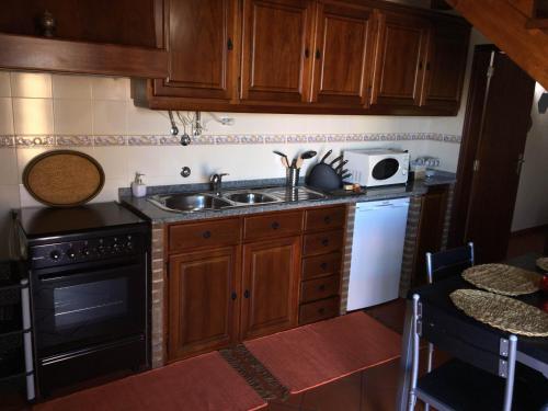 uma cozinha com um lavatório e um micro-ondas em Refúgio da Vila em Monsaraz