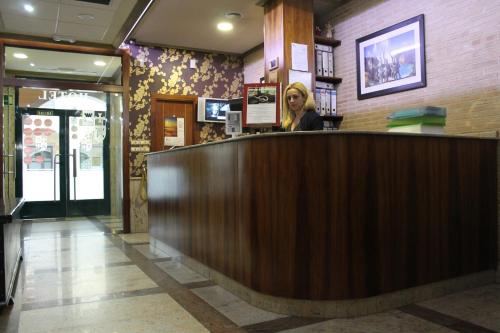 a woman standing at the counter of a restaurant at Hotel El Castillo in Ponferrada