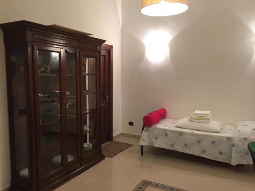ナポリにあるIl Cuore di Napoliのキャビネットとベッドが備わる客室です。