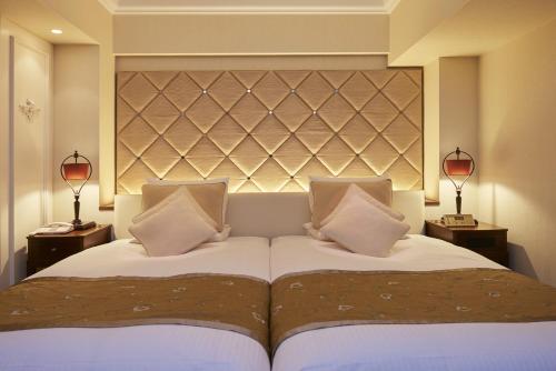 a bedroom with two beds and two lamps at Hotel Okura Tokyo Bay in Urayasu