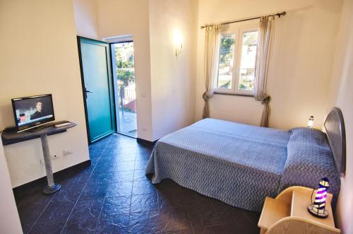 a bedroom with a bed and a television and a window at Cinqueterre Residence in Riomaggiore