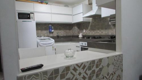 cocina con armarios blancos y encimera en Lindo Apartamento à Beira Mar, en João Pessoa