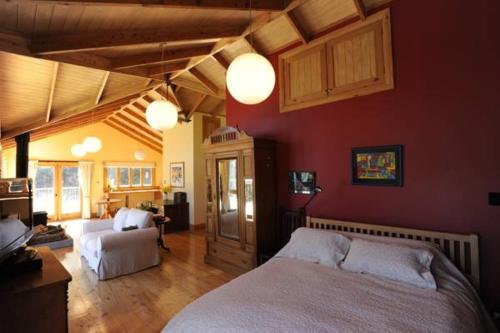 a bedroom with a bed and a living room at Mumfords in Akaroa