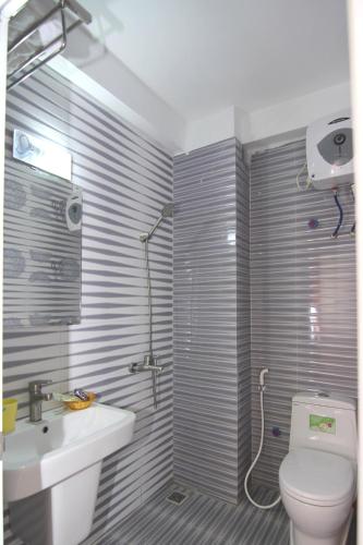 a bathroom with a toilet and a sink and a shower at Huong Cang Sea View Hotel in Cat Ba