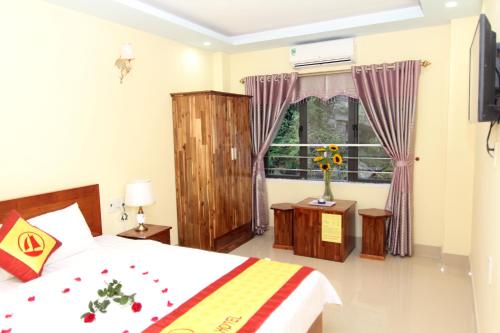 a bedroom with a bed and a window at Huong Cang Sea View Hotel in Cat Ba