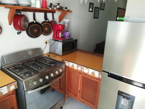 a kitchen with a stove and a refrigerator at Casita Aurora in Chemuyil