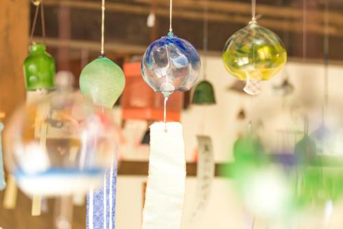 a group of glass ornaments hanging from a ceiling at Teramachiya Wind Bell Temple Guest House in Kanazawa