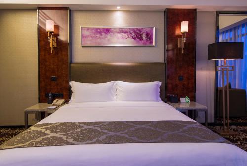 מיטה או מיטות בחדר ב-Zhongtian Mayfair Hotel - Bao'an International Airport Xixiang Subway Station