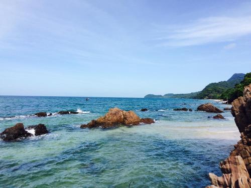 a view of the ocean with rocks in the water at Gardenhomeresortkohjum in Ko Jum