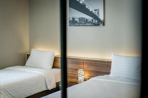 a hotel room with two beds and a mirror at Onix Hotel Bangkok in Bangkok