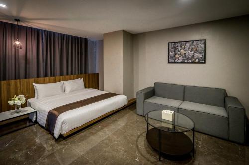 a bedroom with a bed and a couch at Onix Hotel Bangkok in Bangkok