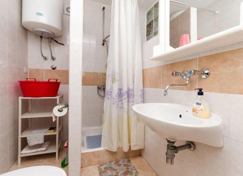 a bathroom with a sink and a toilet and a shower at Apartment Stojna in Lopar