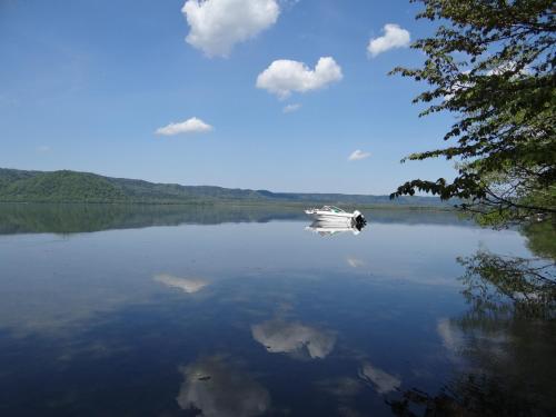 a boat on a large lake with clouds in the sky at Wakkanupuri in Teshikaga