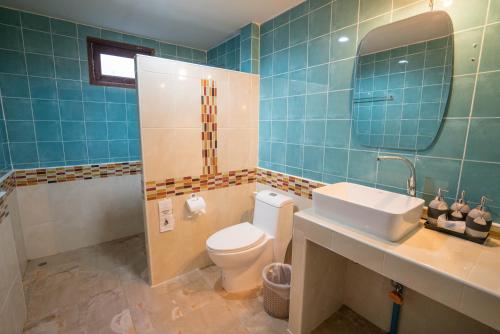 een badkamer met een toilet, een wastafel en een spiegel bij Tonsai Bay Resort in Tonsai Beach