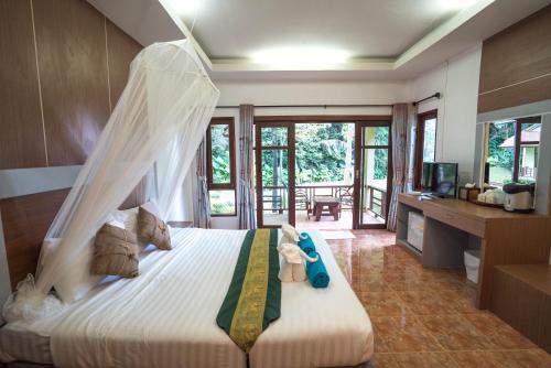 Tonsai Bay Resort في شاطئ تونساي: غرفة نوم بسرير مع ناموسية
