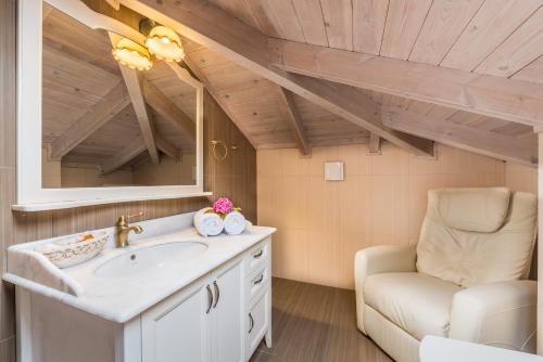 een badkamer met een wastafel en een stoel bij Theofilos Paradise Boutique Hotel in Mytilini